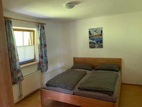 1 cama en un dormitorio con ventana en Ferienwohnung Lehen, en Sankt Veit im Pongau