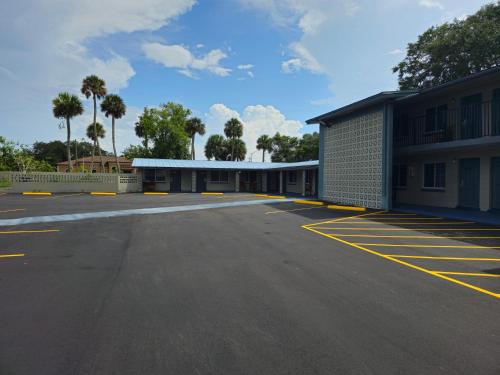 ein leerer Parkplatz vor einem Gebäude in der Unterkunft Three Oaks Motel - Titusville in Titusville