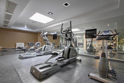 a gym with several exercise bikes and a flat screen tv at Hotel Inn Paris CDG Airport - ex Best Western in Roissy-en-France
