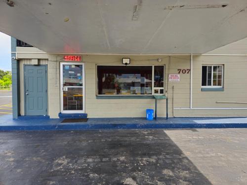 a store front with a blue door on a street at Three Oaks Motel - Titusville in Titusville
