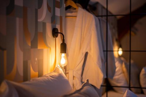 a bedroom with a bed with a light on it at Appart-hôtel de standing avec jacuzzi privatisable en option in Périgueux