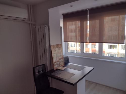 escritorio en una habitación con ventana y silla en Delightful Studio Grigorescu, en Bucarest