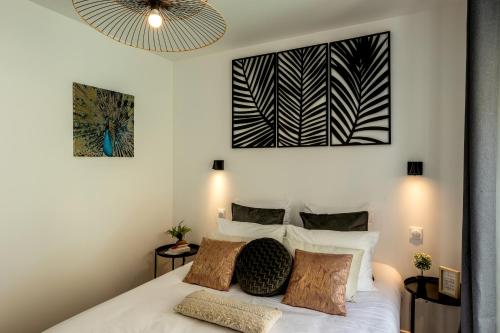 a bedroom with a white bed with two pillows at Appart-hôtel de standing avec jacuzzi privatisable en option in Périgueux