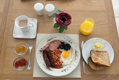 una mesa con un plato de desayuno y una taza de café en HighTree House, en Cork