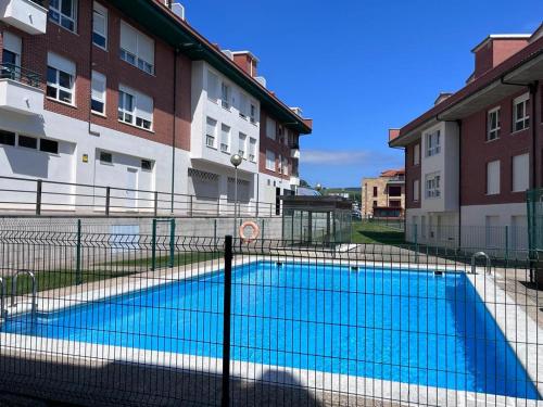 una piscina frente a algunos edificios en Apartamento a estrenar en Ribamontán al Mar, en Hoznayo