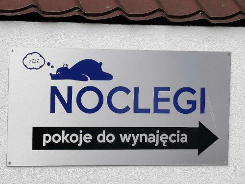 シェミャティチェにあるNoclegiのコアラが貼られた建物の脇の看板