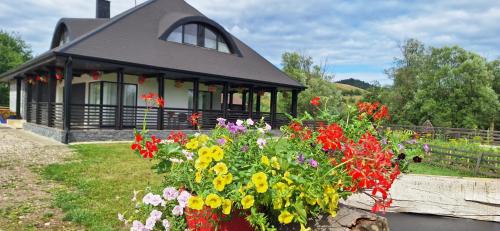 Ein Haus mit einem Haufen Blumen davor in der Unterkunft Casa Bukovina in Kloster Humor