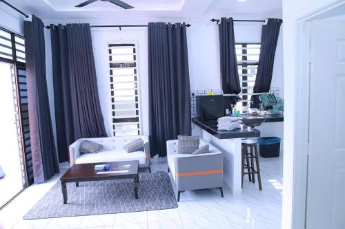 ein Wohnzimmer mit einem Stuhl und einem Schreibtisch in der Unterkunft Green Dream Homestay 2 Kota Bharu Town 3 Aircond Room With Wifi & Netflix in Kota Bharu