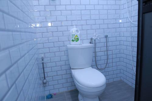 ein Bad mit einem WC in einer weiß gefliesten Wand in der Unterkunft Green Dream Homestay 2 Kota Bharu Town 3 Aircond Room With Wifi & Netflix in Kota Bharu