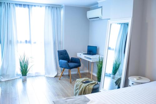 a bedroom with a desk and a chair and a mirror at Луксозен Апартамент в Модерна сграда -Молимаркс Делукс Апартамент Бургас in Burgas City
