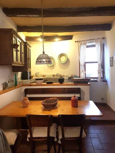 a kitchen with a wooden table with chairs and a dining room at Casa Della Rosa in Pitigliano