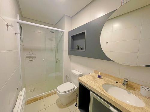 ein Badezimmer mit Toilette, Waschbecken und Dusche in der Unterkunft Espaçoso apto no Centro de Gramado in Gramado