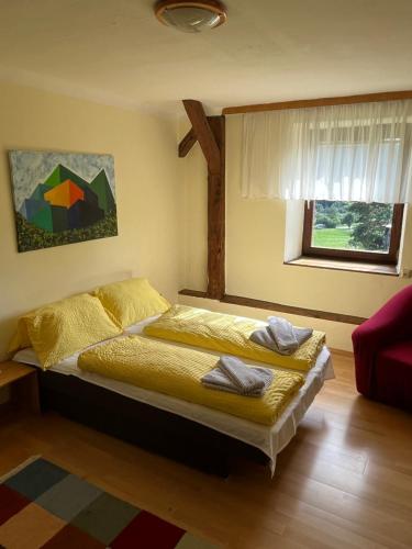 a bedroom with a bed with yellow sheets and a window at Privatzimmer Familie Pair/Schmoll in Spital am Semmering