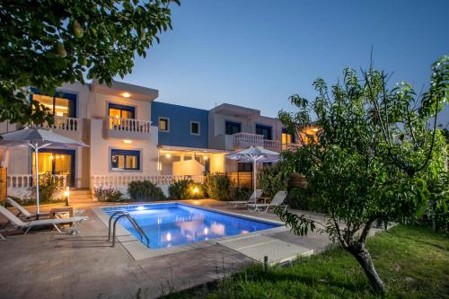 a villa with a swimming pool in front of a house at RITA MARE seafront villas in Gennadi