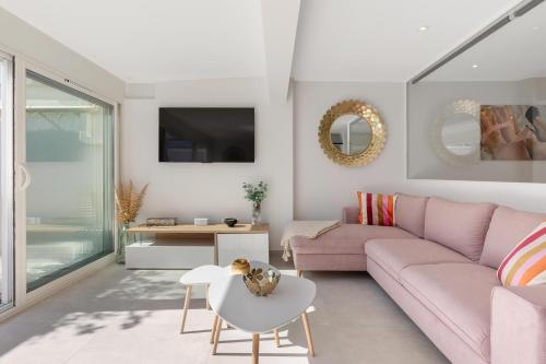 un salon avec un canapé rose et une table dans l'établissement Village Naturiste R4N - La Villa Gypsea Luxe, au Cap d'Agde