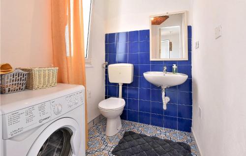 La salle de bains est pourvue de carrelage bleu, d'un lave-linge et d'un lavabo. dans l'établissement Amazing Home In Trappeto With Wifi, à Trappeto