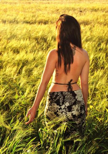 a woman is walking through a field of grass at Viva Tourismo Resort (naturist club) in Paradeísion