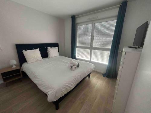 - une chambre avec un lit doté de draps blancs et une fenêtre dans l'établissement Appartement T2 -Parking -35Min Paris RER 2Min à Pied, à Évry-les-Châteaux