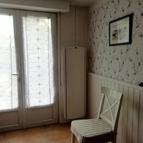 Cette chambre dispose d'une chaise, d'un réfrigérateur et de fenêtres. dans l'établissement Maison La Belvérine, à Beauvoir-sur-Mer