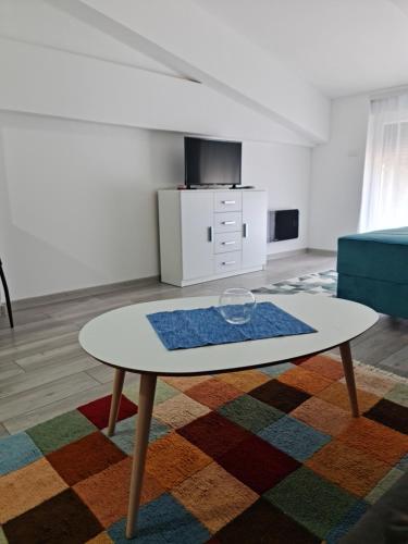 een woonkamer met een tafel en een bank bij Studio apartmani Banja Koviljaca in Banja Koviljača