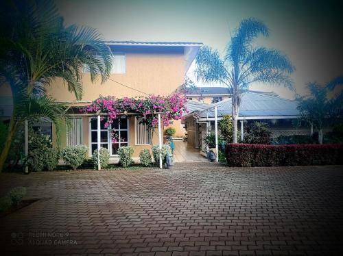 a house with pink flowers on the side of it at Hotel Maea Hare Repa in Hanga Roa