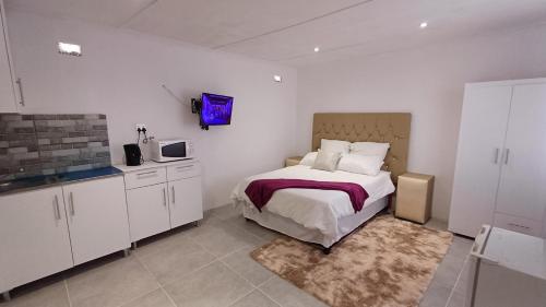 ein Schlafzimmer mit einem Bett und einer Mikrowelle. in der Unterkunft Ozizi Lodge in East London