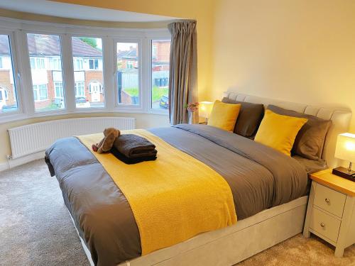 um quarto com uma cama grande e um cobertor amarelo em Beautiful Home, BHX Airport, NEC, King Size Beds, Free Parking em Sheldon
