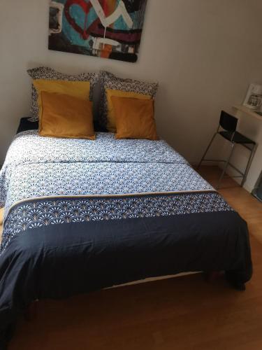 a bedroom with a bed with a blue and white comforter at Loux in Lyon