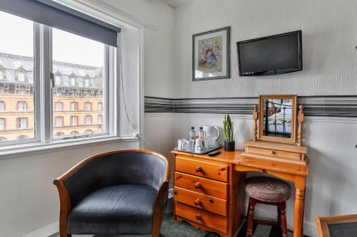 a room with a desk and a chair and a mirror at Serenity Guest House in Scarborough