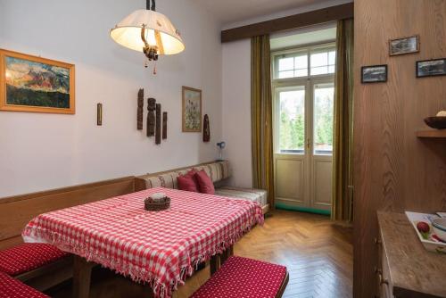 a room with a table with a red and white table cloth at ROMANTICO BILOCALE CON PANORAMA MOZZAFIATO in Nova Levante