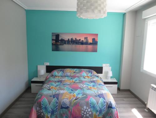 1 dormitorio con cama y pared azul en EL EDEN De SALAMANCA, en Villares de la Reina