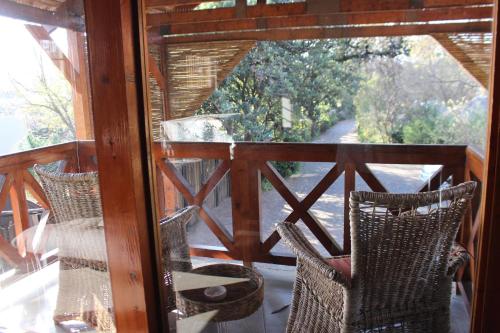 a balcony with two chairs and a table and a window at Ikamu's lodge in Germiston