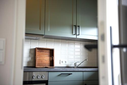 a kitchen with white cabinets and a sink at Romantik Hotel Jagdhaus Eiden am See in Bad Zwischenahn