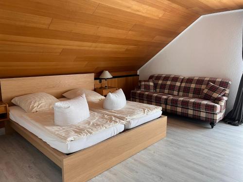 ein Schlafzimmer mit einem Bett und einem Sofa in der Unterkunft Hotel Restaurant Körber in Osterwald Unterende