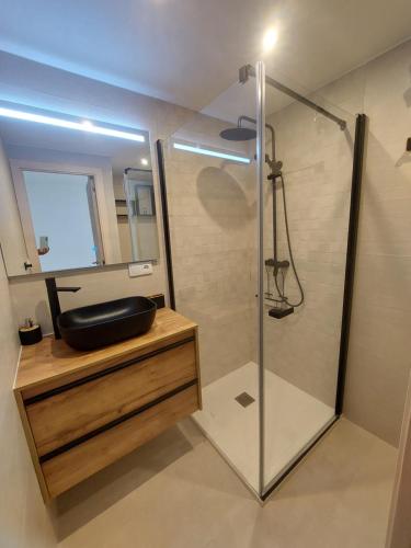 łazienka z prysznicem, umywalką i lustrem w obiekcie Bungalow Alkabir Playa w mieście El Campello