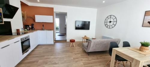 a kitchen and living room with a table and a dining room at Le P'tit Patio, Terrasse privative. in Lanester