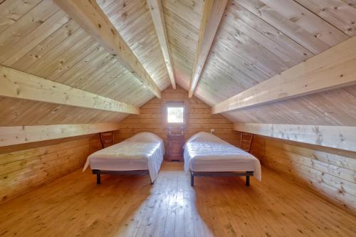 une chambre avec deux lits dans une cabane en bois dans l'établissement Etaules, Nouvelle-Aquitaine, charmant chalet, à Étaules