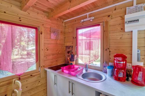 une cuisine avec un évier dans une cabane en rondins dans l'établissement Etaules, Nouvelle-Aquitaine, charmant chalet, à Étaules