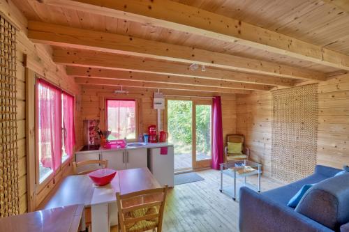 une cuisine et un salon dans une cabane en rondins dans l'établissement Etaules, Nouvelle-Aquitaine, charmant chalet, à Étaules