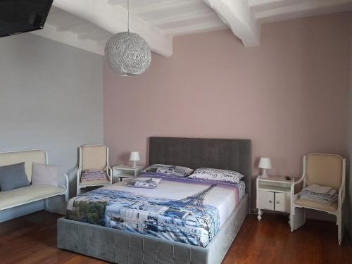 1 dormitorio con cama, sofá y sillas en La maison de nonnì, en Buonconvento