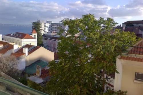 uma vista para uma cidade com uma árvore e edifícios em Sunny Double Room in a Shared Apartment close to Lisbon Downtown em Lisboa