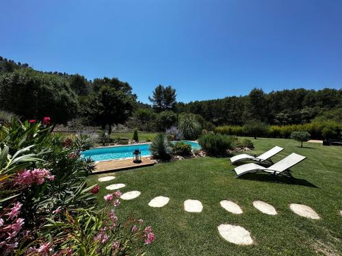 a yard with two chairs and a swimming pool at Les Prairies de Fenestrelle Spa & Piscine au calme in Aubagne