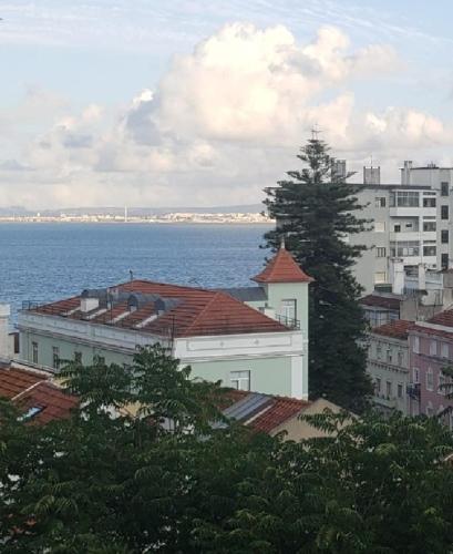 uma vista para uma cidade com o oceano e edifícios em Sunny Double Room in a Shared Apartment close to Lisbon Downtown em Lisboa