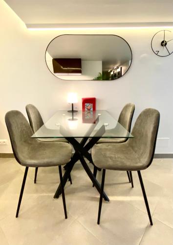 a dining room table with four chairs and a mirror at Duplex Cosy au Cœur du Vieux-Nice in Nice