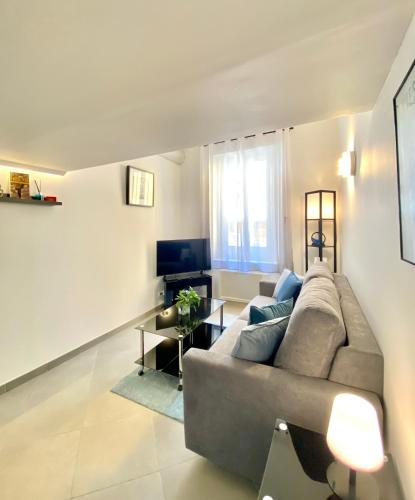 a living room with a couch and a television at Duplex Cosy au Cœur du Vieux-Nice in Nice
