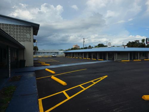 um parque de estacionamento vazio com linhas amarelas no chão em Three Oaks Motel - Titusville em Titusville