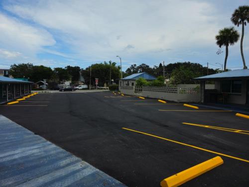 ein leerer Parkplatz mit gelben Linien drauf in der Unterkunft Three Oaks Motel - Titusville in Titusville
