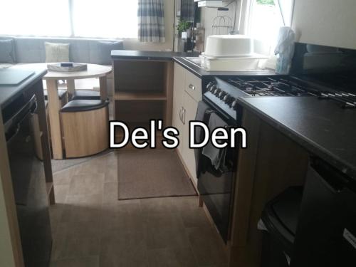 a kitchen with a sink and a stove top oven at Del's den lakeside weeley bridge in Weeley