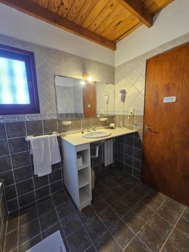 La salle de bains est pourvue d'un lavabo et d'un miroir. dans l'établissement Posada Aitue, à Villa General Belgrano