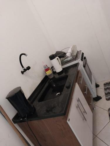 a small kitchen with a sink and a microwave at Apto Ruan Pelinca in Campos dos Goytacazes